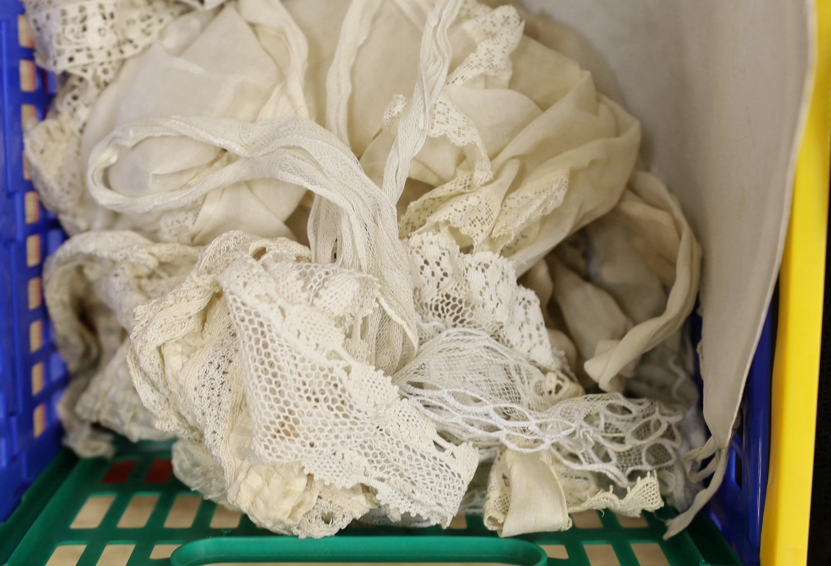 A suitcase of mixed 19th and 20th century black machine and bobbin laces, servants bonnets, cream lace, etc